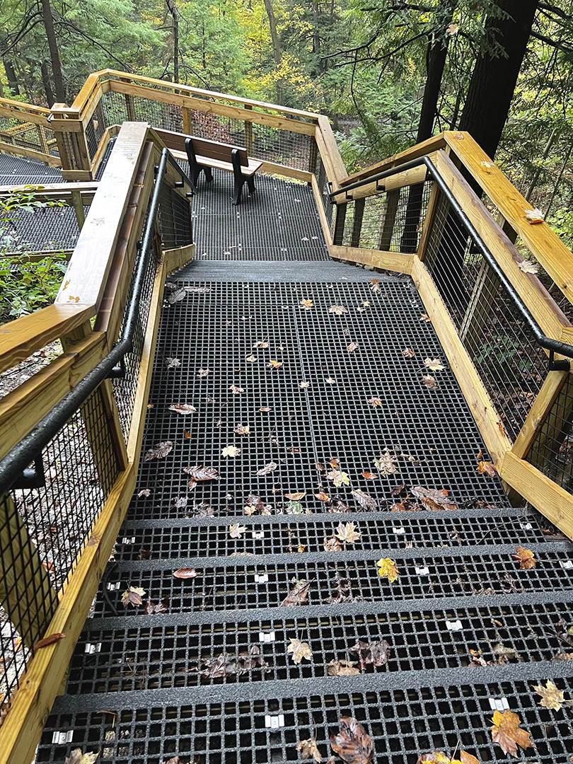 Fiberglass grating steps with wire mesh handrail inserts in a national park, similar to products provided by Direct Metals®.